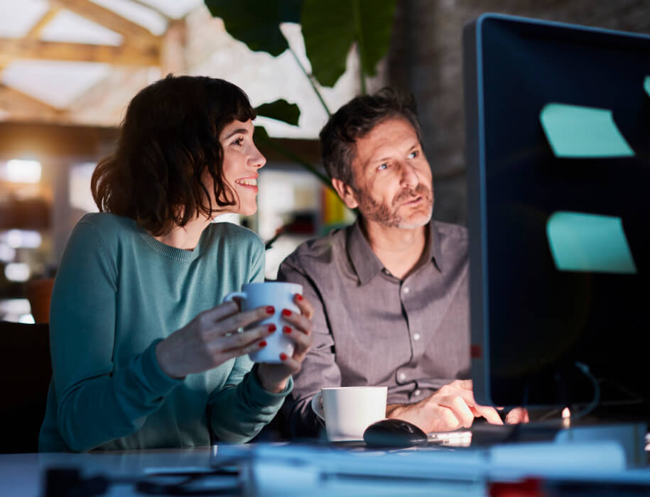 Two coworkers looking at a computer screen