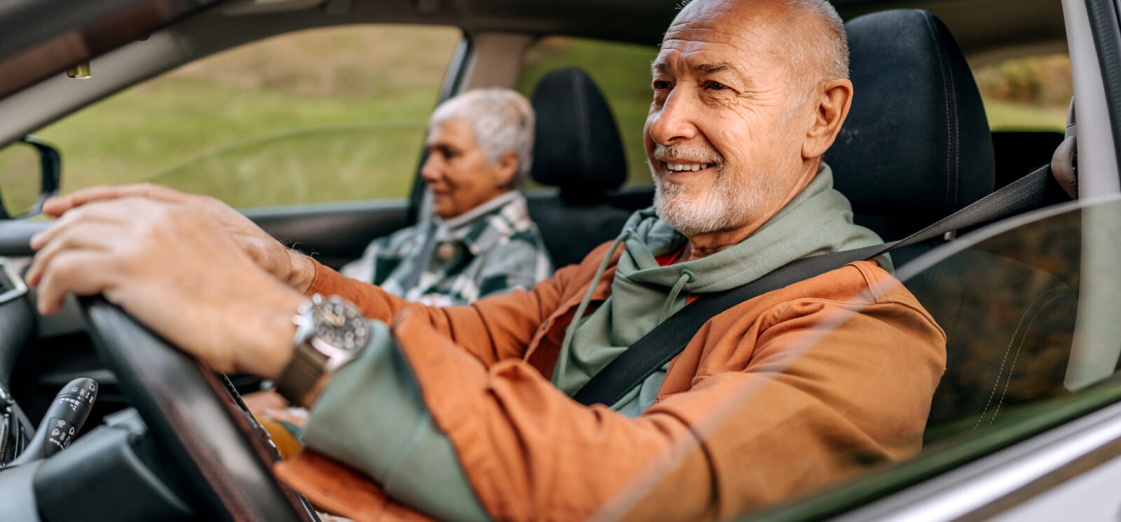 Mature couple driving in a nice car