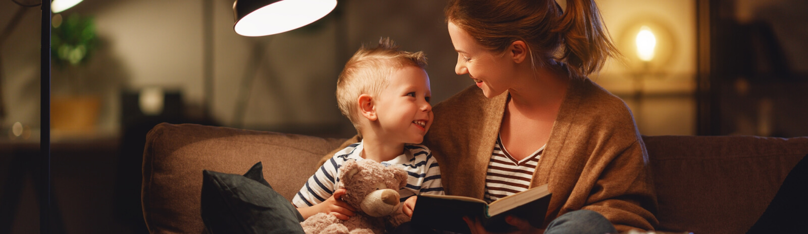 a mom reading a book to a young boy