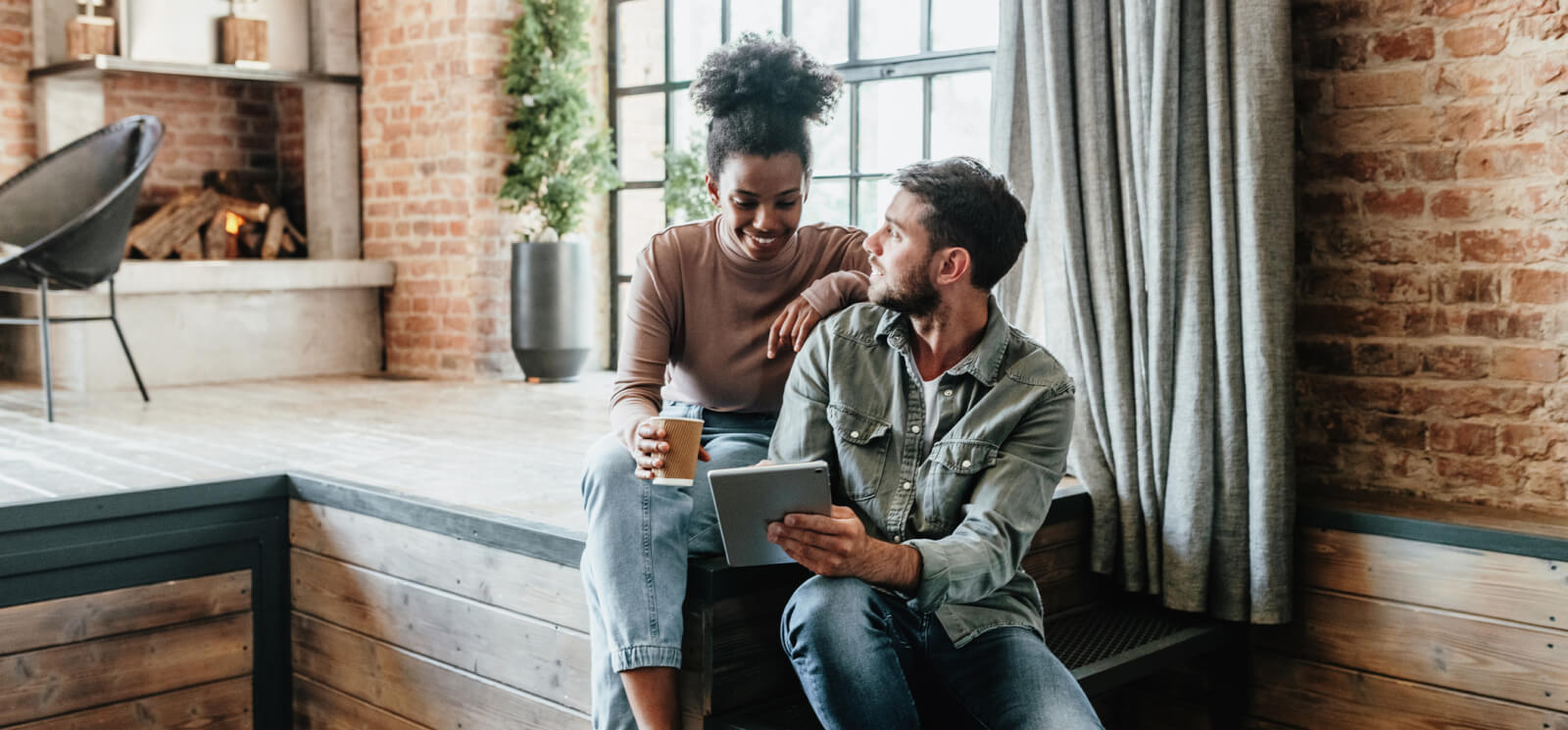 Young couple sitting and looking at a tablet